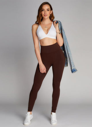 A woman wearing brown high waisted leggings. 