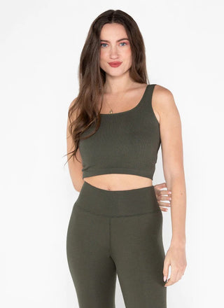 A woman wearing a square neck crop tank in a green color, with the tank displaying a ribbed texture.
