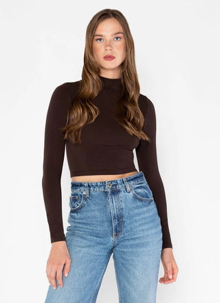 a women wearing a crop brown long sleeve mock neck top made of bamboo