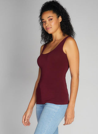 A woman wearing a bamboo tank top with short length, paired with jeans.