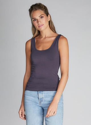 A woman wearing a bamboo tank top with short length, paired with jeans.