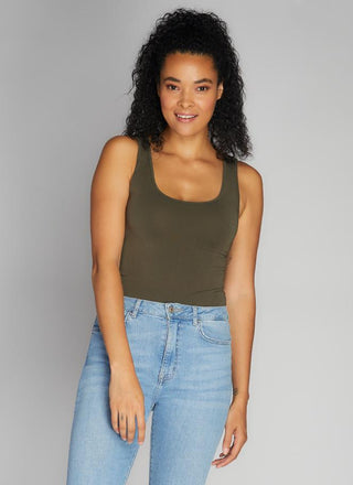 A woman wearing a bamboo tank top with short length, paired with jeans.