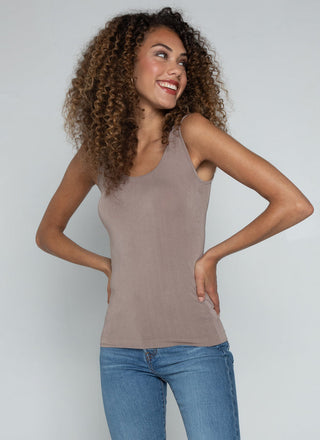 A woman wearing a bamboo tank top with short length, paired with jeans.
