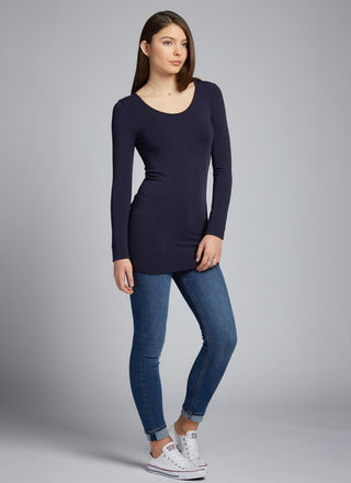 A woman wearing a long sleeve scoop neck top in blue, paired with blue jeans. 