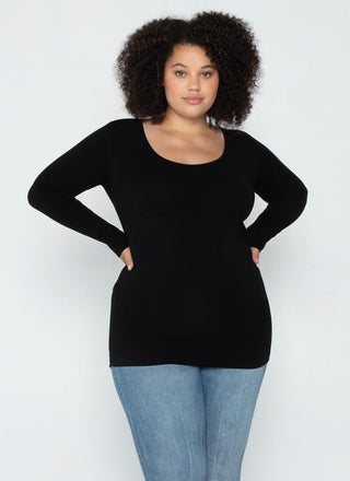 A woman wearing a black long sleeve curvy scoop neck top paired with blue jeans.