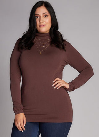 A plus-size model wearing a brown bamboo curvy turtleneck top.