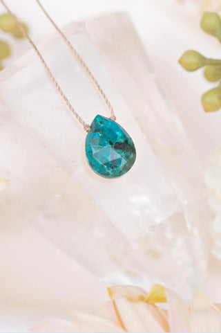 a close up on a blue crystal on the end of a necklace from Soulku