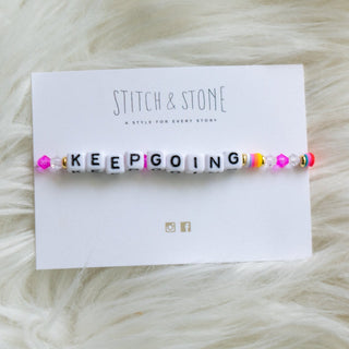 Bracelet with motivational message on wrist against a neutral background