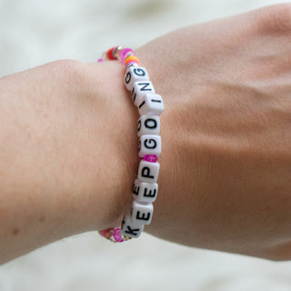 Bracelet with motivational message on wrist against a neutral background
