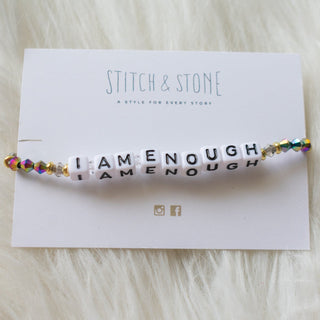 Bracelet with motivational message on wrist against a neutral background