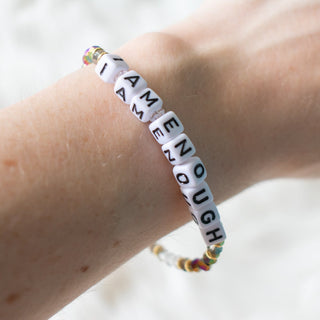 Bracelet with motivational message on wrist against a neutral background
