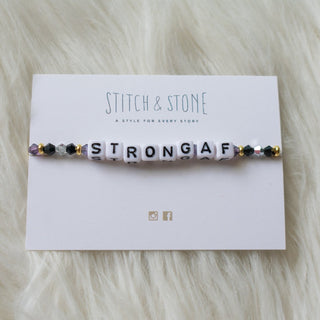 a beaded bracelet that says strong AF on it