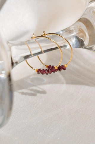 gold hoop earrings with red crystal beads on them,