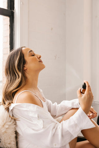 women spraying her face with a toner