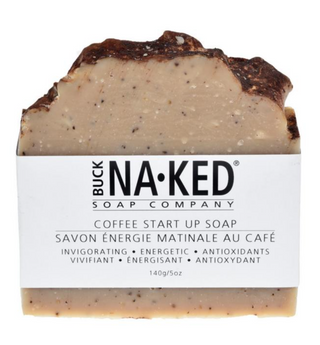 A bar of soap with a textured surface and a label that reads 'COFFEE START UP SOAP' along with the Buck Naked Soap Company branding.