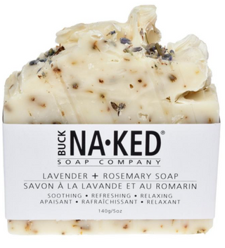 A bar of soap with speckles, predominantly white, with packaging that reads 'BUCK NAKED SOAP COMPANY LAVENDER + ROSEMARY SOAP'.