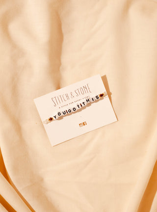 Bracelet on a card with 'Stitch & Stone' branding on a beige fabric background
