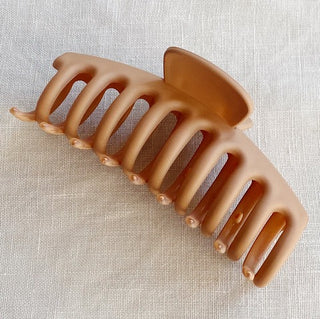 a plastic claw clip in a taupe colour