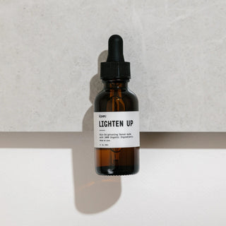 Brown glass dropper bottle labeled 'LICHTEN UP' on a light background